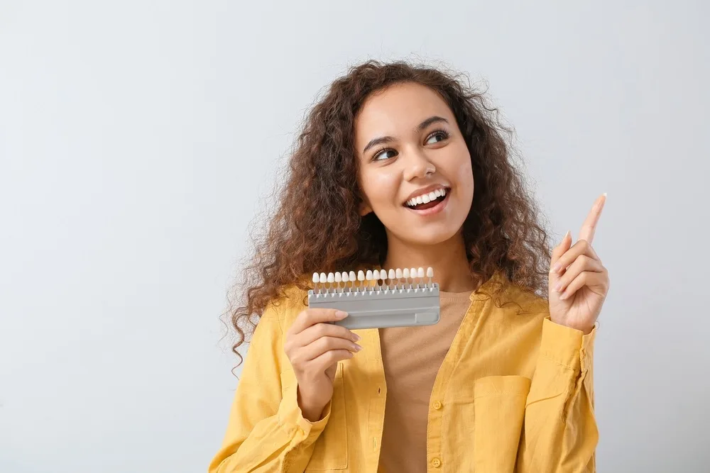 Woman holding a teeth whitening chart - Porcelain Veneers in Carmel Valley