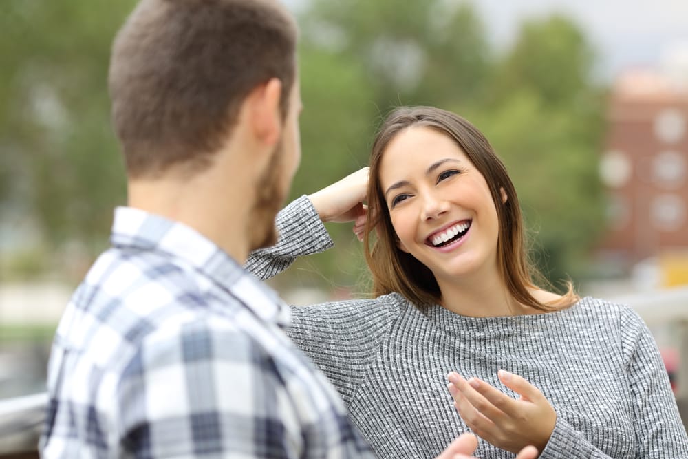 Happy casual couple talking looking each other sitting in a balcony - Dental Bonding in Carmel Valley