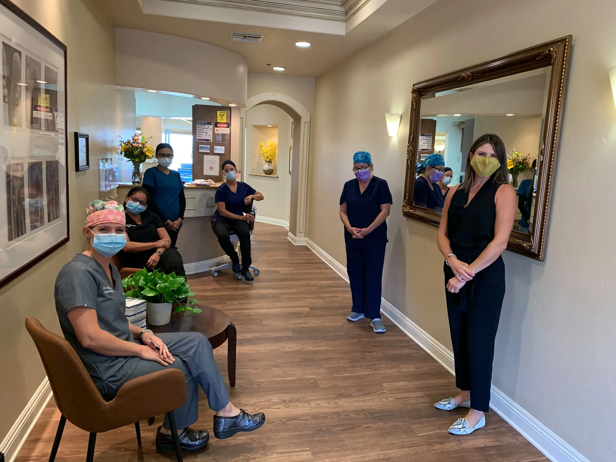 Dr. Lindsay Bancroft, DDS smiling and wearing a lavender colored top with tree branches behind her - Carmel Valley Dental