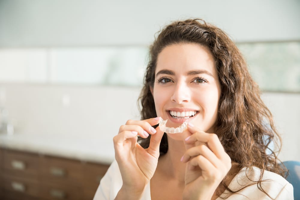 Woman holding an Invisalign in Carmel Valley