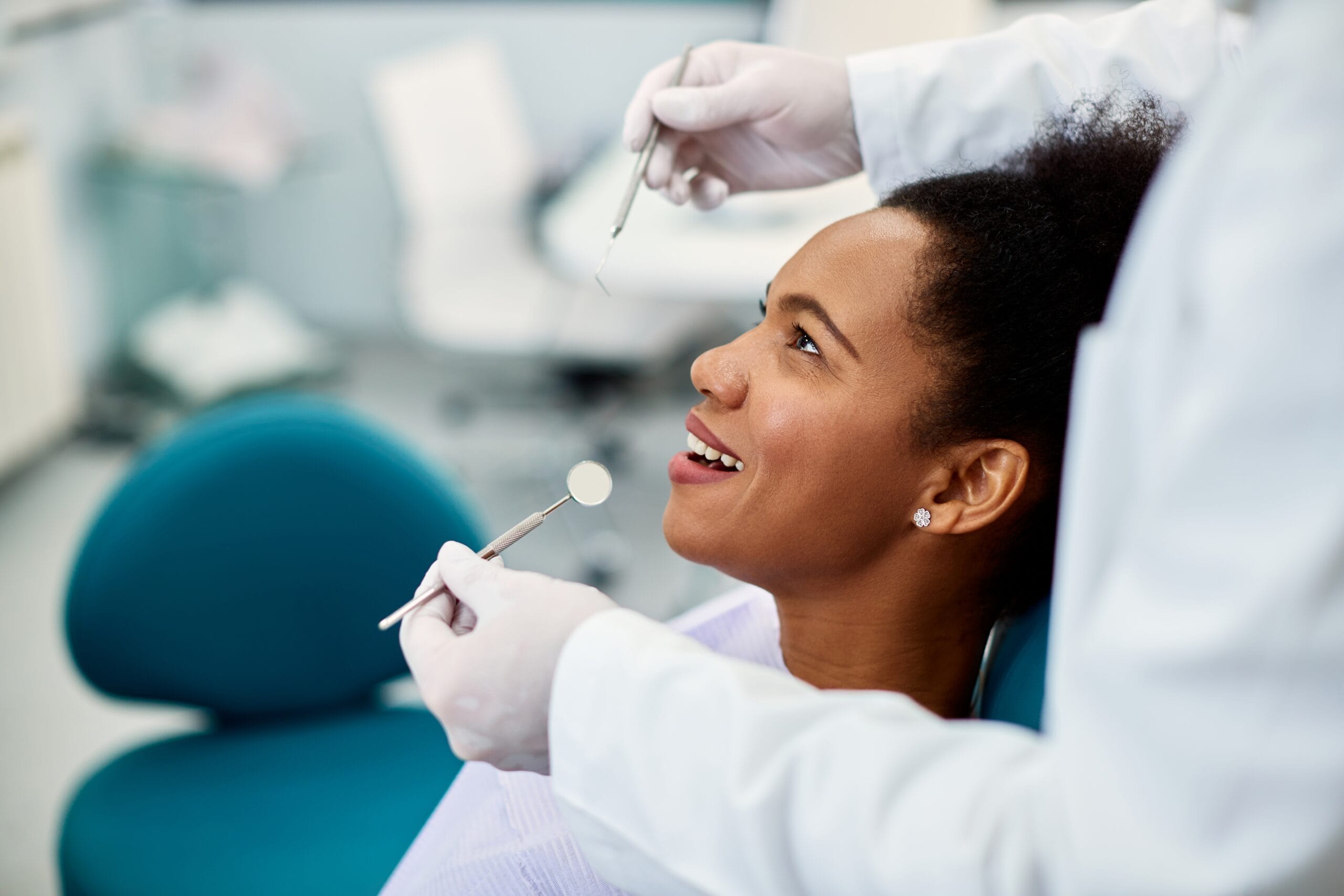 woman sitting in dental chair at medical - Dental Exams