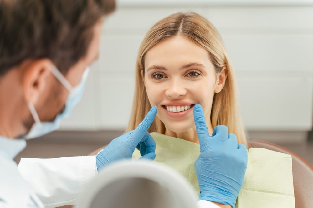 young woman with toothy smile sitting in dental chair - Root Canals